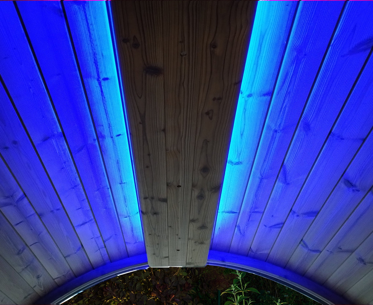 Blue LED chromotherapy accent lighting illuminating the wood ceiling of a barrel sauna